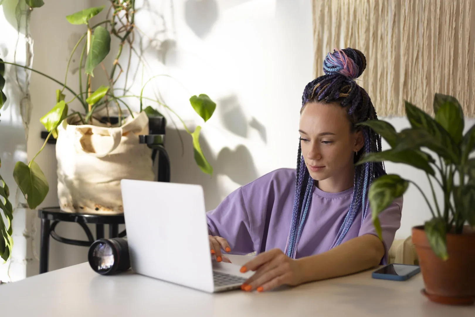 Graduação EaD para deficientes visuais: principais vantagens | Jovem mulher de tranças sentada em frente ao notebook | UNIFAVENI