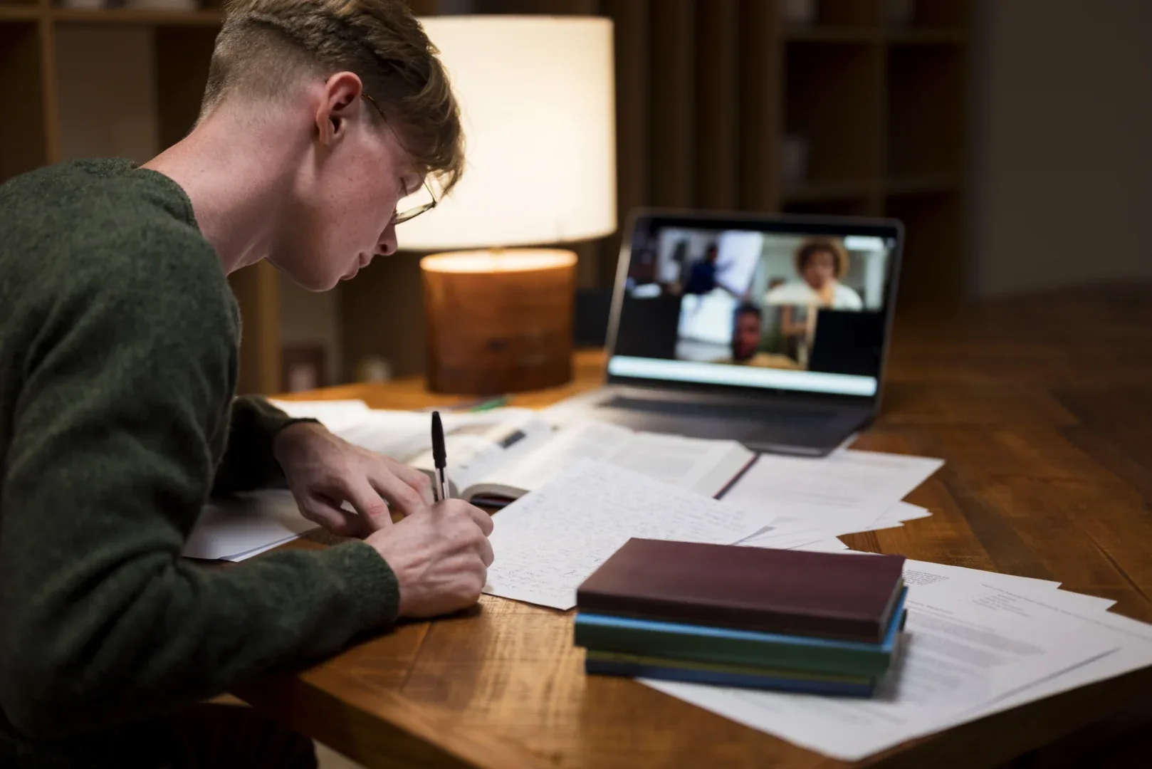 Qual é o papel do EaD na democratização do ensino superior? | Foto de jovem assistindo aula online e fazendo anotações | UNIFAVENI