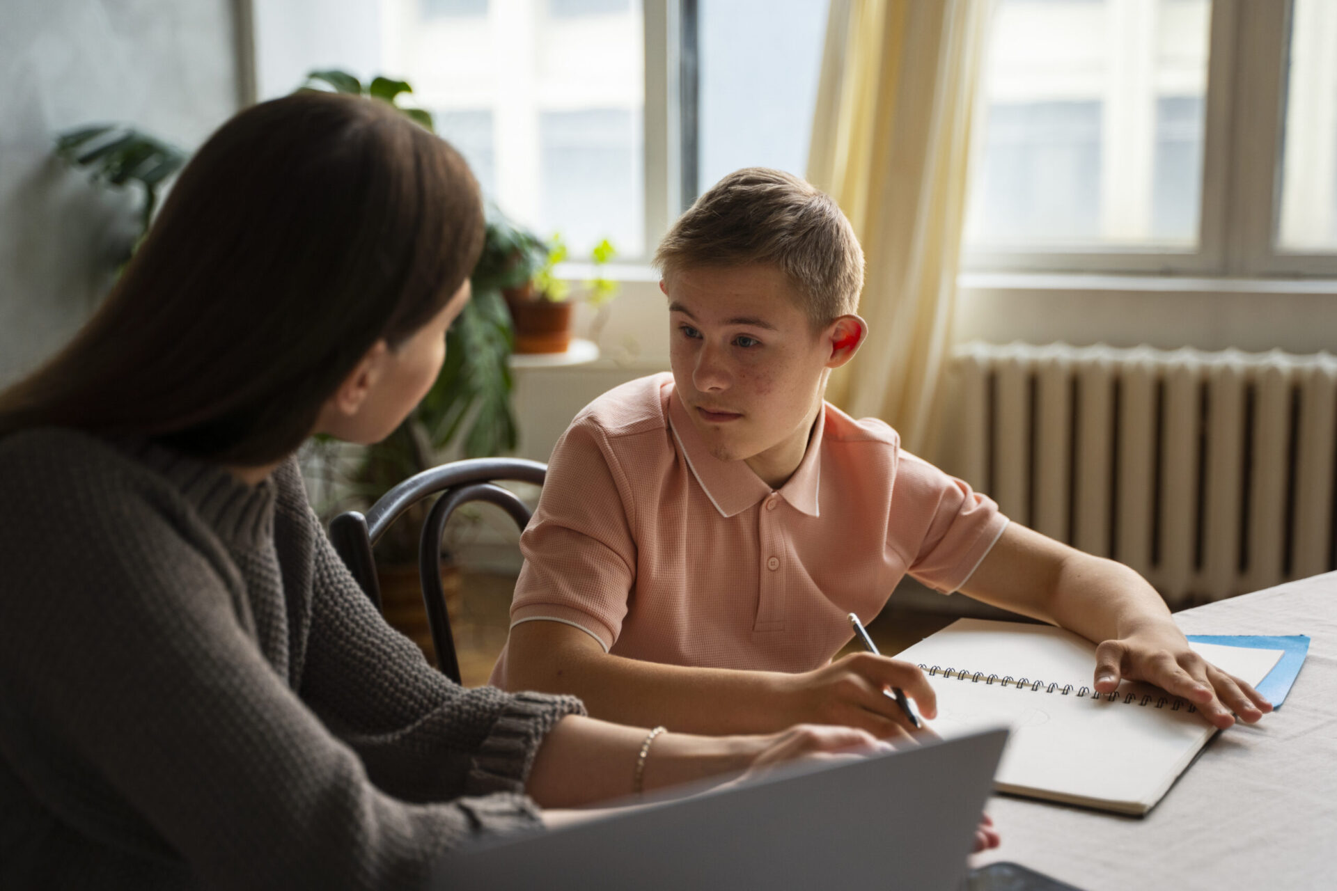 Como escolher a pós-graduação em Educação Especial online? | Professora auxiliando um aluno com síndrome de down | UniFaveni