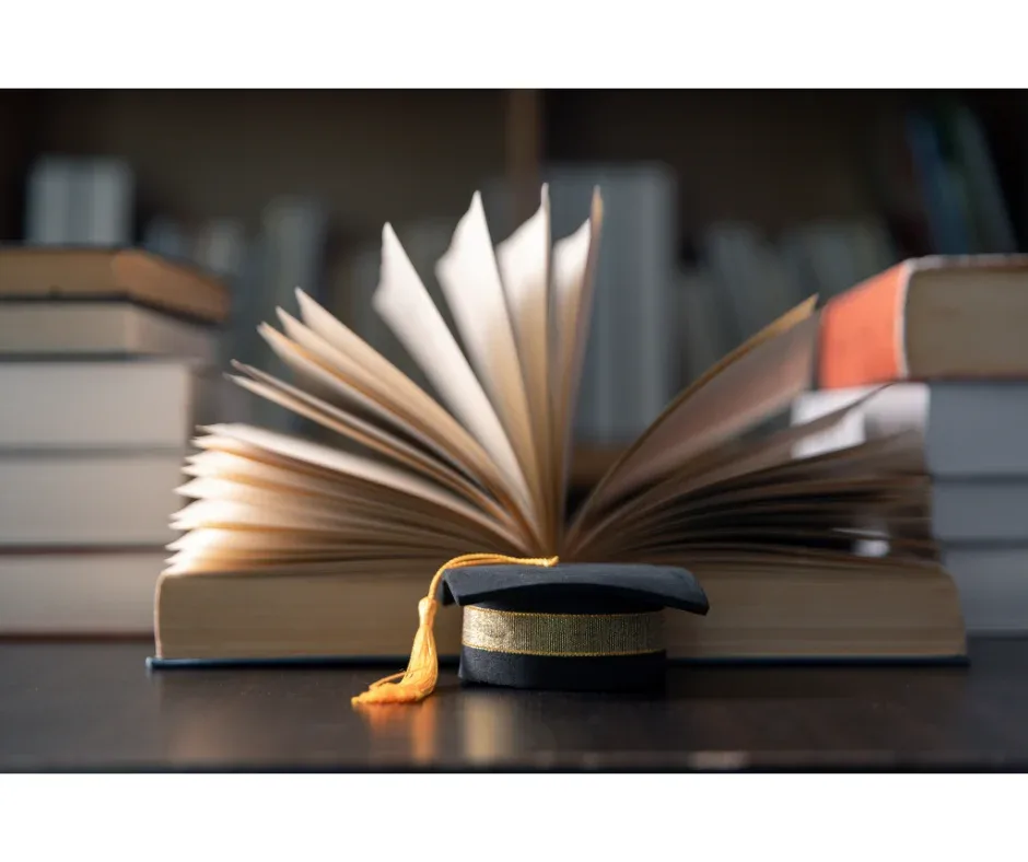 Apoio psicológico no ensino superior: qual é a importância? | Foto de uma mini beca em cima de uma mesa e um livro aberto atrás | UNIFAVENI|Apoio psicológico no ensino superior: qual é a importância? | Foto de uma garota muçulmana estudando no notebook | UNIFAVENI