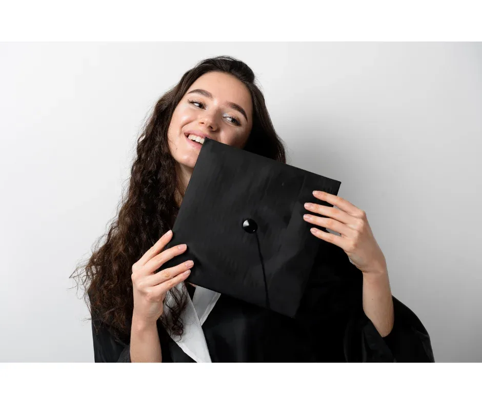 Curso de graduação EaD: 4 motivos para escolher a UNIFAVENI | Jovem sorrindo vestindo uma beca e segurando um capelo | Nome do Cliente|Curso de graduação EaD: 4 motivos para escolher a UNIFAVENI | Jovem loira sorrindo vestindo beca e capelo em frente ao computador | UNIFAVENI