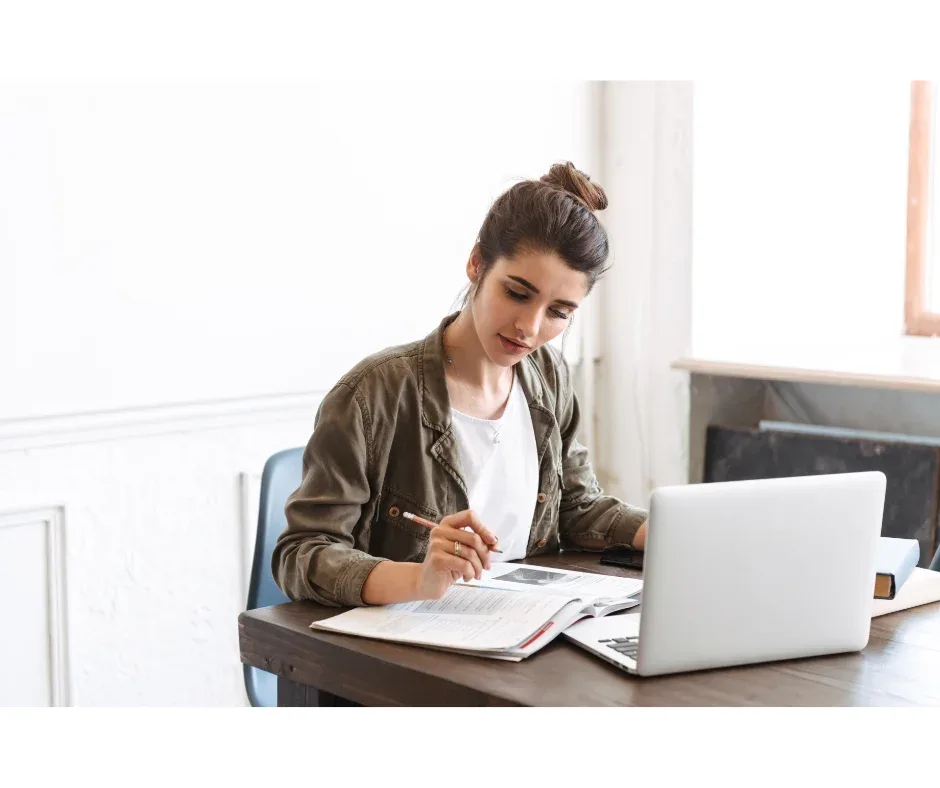 Foco nos estudos EaD: como manter a concentração? | Jovem mulher estudando em casa | UNIFAVENI|Foco nos estudos EaD: como manter a concentração? | Foto superior de algum estudando | UNIFAVENI